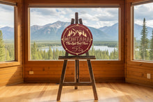 Wooden circle sign with 'Montana The Last Best Place' design shown over a scenic background of a lake and mountains. Made in Montana