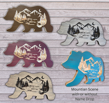 Bear-shaped wooden cutouts with mountain and forest designs on a wooden surface.